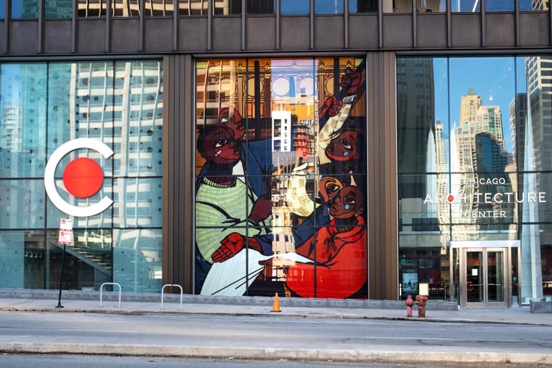 exterior of glass building with large mural