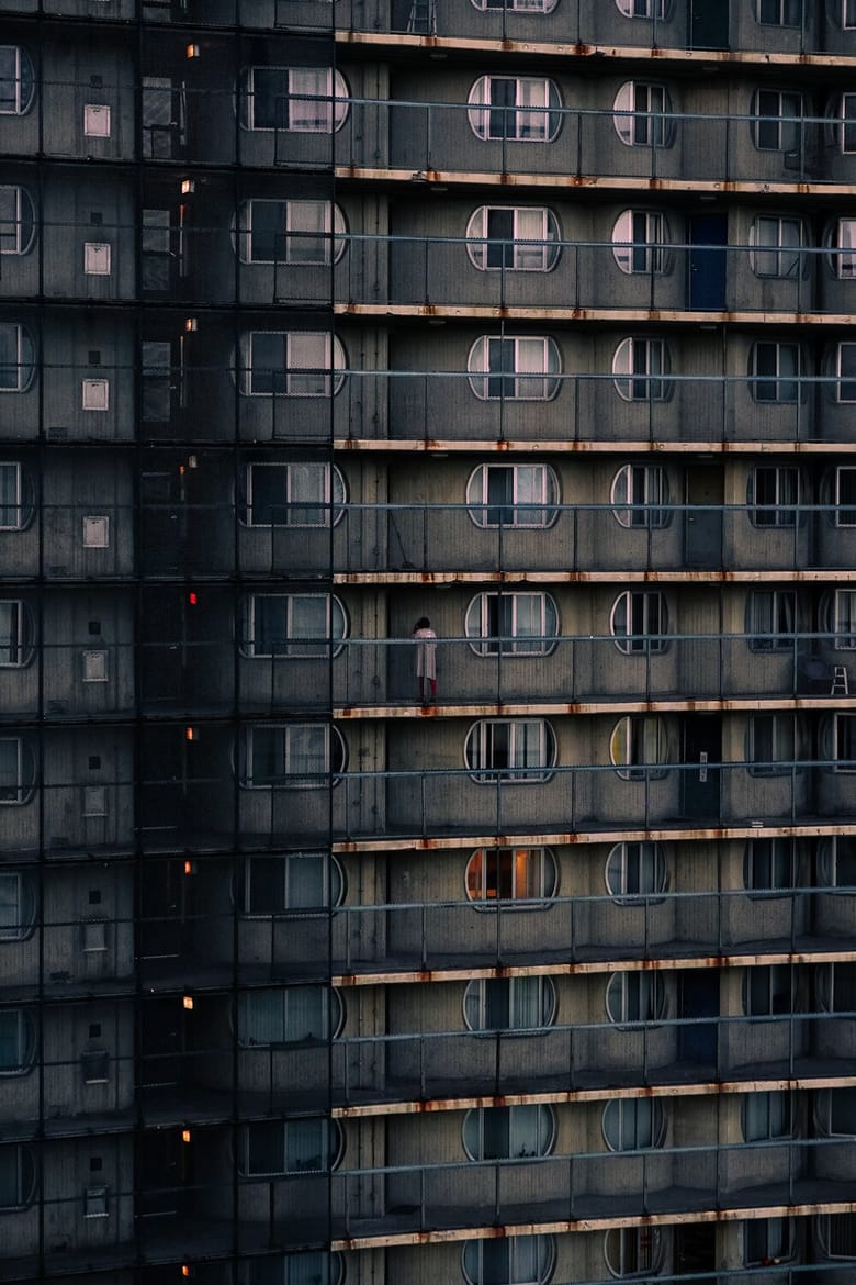 A tall building with many different floors, showing the different balconies.