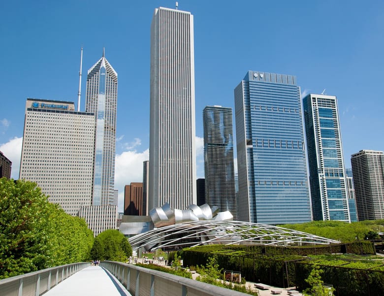 Image of a skyline with greenery and an arched metal structure in the foreground. 